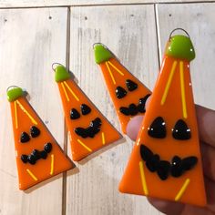 three pieces of orange and black glass with bats on them, one is shaped like a cone