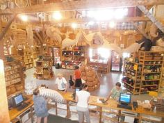 people are standing in the middle of a store with many items on tables and shelves