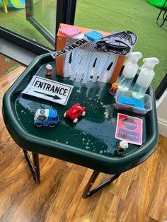 a green table topped with lots of different types of cleaning products on top of it