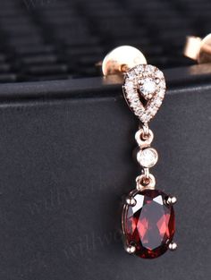 - Metal: Solid gold(10K/14K/18K white/yellow/rose gold),925 sterling silver,platinum available- Main Stone: 5x7mm oval cut natural red garnet- Accent Stone: diamonds or moissanites- Band Width: 1.4mm- Can be personalized: Yes Rose Gold Oval Earrings For Anniversary, Oval Diamond Rose Gold Earrings, Elegant Garnet Earrings For Anniversary, Oval Rose Gold Diamond Earrings, Oval Garnet White Gold Jewelry, Elegant Oval Garnet Earrings, Luxury Oval Garnet Jewelry, Elegant Faceted Garnet Earrings, Gold Faceted Garnet Earrings