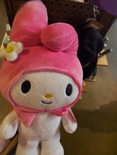 a hello kitty stuffed animal with a pink hat and flower on it's head