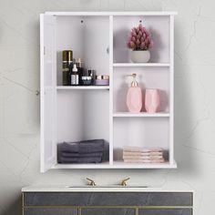 a white shelf with towels, soaps and other items on it against a blue wall