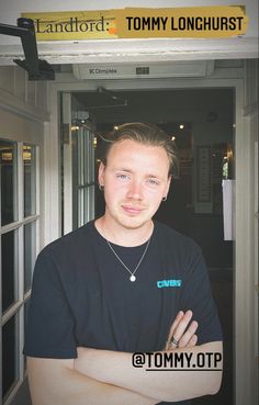 a man standing in front of a door with his arms crossed