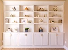 a living room filled with lots of white furniture and shelves on top of each other