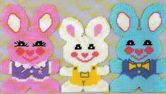 three cross stitch bunnies in different colors and sizes, one is wearing a bow tie