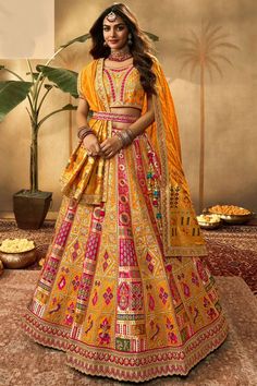 a woman in an orange and yellow lehenga