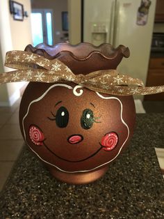 a brown pot with a face painted on it