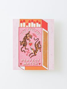 a pink and orange greeting card with two tigers on the front, surrounded by candles