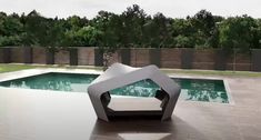 an artistic sculpture sits in front of a pool