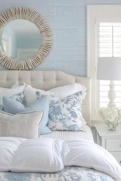 a white bed with blue and white pillows