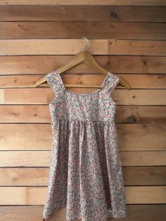 This cute little dress is a classic design that will look adorable on any little girl. Pull over style with lots of brightly coloured flowers made in Liberty Tawny lawn.  100% Cotton Age.      Chest      Waist.     Hips  1.              20.          19.5.           -  2.              21.          20.              -  3.              22.         20.5.           -  4.              23.         21.             24  5.              24.         21.5.          25  6.              25.         22. Playful Cotton Floral Print Sundress, Playful Floral Print Cotton Dress, Cute Cotton Floral Print Dresses, Cute Cotton Dresses With Floral Print, Cute Cotton Dress With Floral Print, Summer Cotton Sundress With Ditsy Floral Print, Playful Multicolor Cotton Floral Dress, Cotton Floral Print Sundress For Playtime, Fitted Multicolor Floral Dress