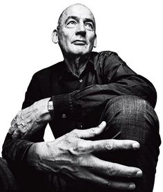 black and white photograph of an older man with his hands on his knees looking up