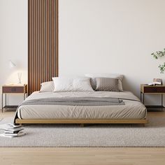 a large bed sitting on top of a wooden floor next to a wall mounted lamp