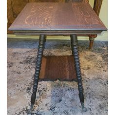 an old wooden table with turned legs and wood grain on the top, sitting in a room