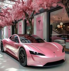 a pink sports car parked in front of a store with cherry blossoms on the trees