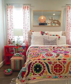 a bed with colorful bedspread and pillows in a room