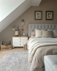 a white bed sitting under a skylight in a bedroom next to a dresser and chair