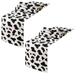 two black and white cow print tablecloths on top of each other with pink spots