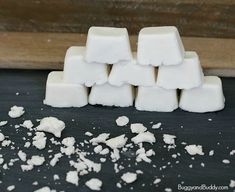 several cubes of marshmallow sitting on top of a black surface next to a wooden board