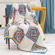 a crocheted blanket is sitting on a chair