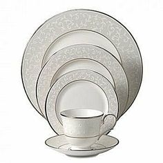 a white dinner set with four cups and saucers