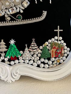 an ornate white frame with beaded christmas trees and other decorations on the front side