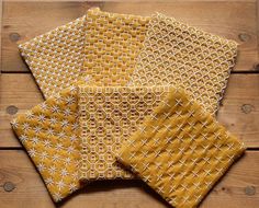 four pieces of yellow fabric sitting on top of a wooden table