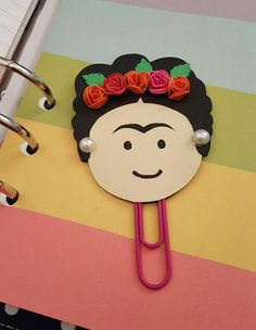 a binder with flowers on it and a paper clip in the shape of a woman's face