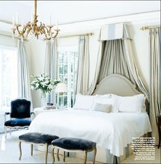 a bed room with a neatly made bed and a chandelier