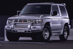 a silver suv is parked in front of a black background