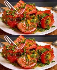 two white plates topped with sliced tomatoes and green garnish on top of each other