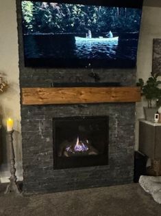 a flat screen tv mounted above a fireplace in a living room