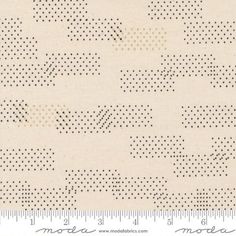 a white background with black dots on it, and a ruler in front of it