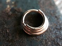 I made this lovely septum ring entirely from solid 14 karat rose gold. It is made to look layered. Twist open and closed to keep the circle shape, the ends are smooth for easy insertion. Can be worn in a variety of piercings. This nose ring is finished with a shiny high polish. Choose your gauge and inside diameter for a custom fit! Comes beautifully packaged and ready for gift giving! Check out my other nose rings here: https://www.etsy.com/shop/DinanRings?section_id=13671263&ref=shopsectio Septum Piercing, Nose Rings, Nose Ring Stud, Ear Piercing, Gold Dipped, Circle Shape, Tragus, Conch, Piercing Jewelry