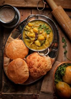 a plate with bread, soup and rolls on it