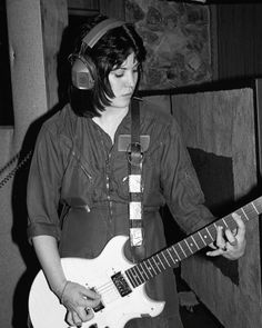 a young man wearing headphones playing an electric guitar