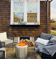 a fire pit sitting in front of a brown house