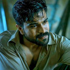 a man with wet hair and beard wearing a tan shirt