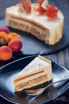 a piece of cake on a plate with a fork and some fruit in the background