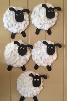 four sheep made out of yarn sitting on top of a wall