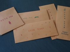 five envelopes with writing on them sitting on a blue tableclothed surface, one has a birthday card and the other has a happy birthday message