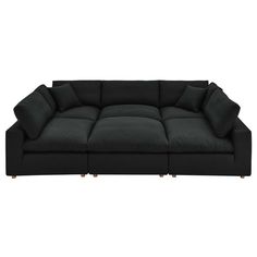 a large black couch with pillows on it's back and arms, in front of a white background