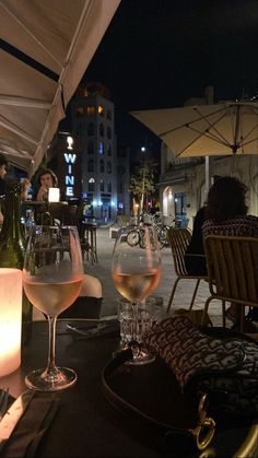 two wine glasses sitting on top of a table