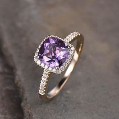 an amethorate and diamond ring sitting on top of a cement slab,