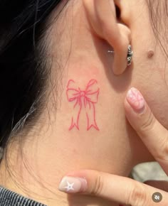 a woman with a pink bow tattoo on her neck