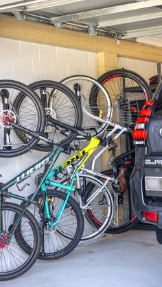 a car parked next to a bunch of bikes in a garage