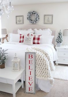 a bedroom with white bedding and christmas decorations