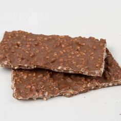 two pieces of chocolate with nuts on top