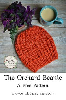 an orange knitted beanie next to a cup of coffee