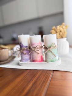 three candles sitting on top of a wooden table